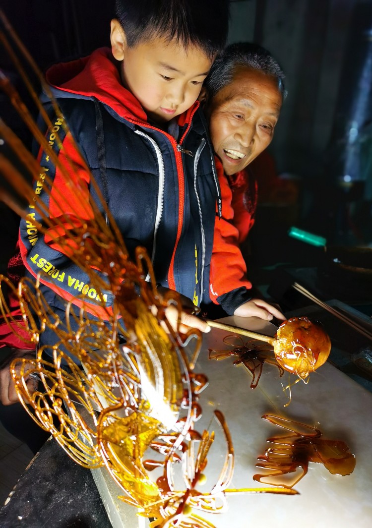 魏松建教孙子绘制糖画.jpg